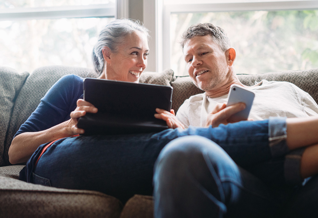 Couple looking at a website on their laptop.
