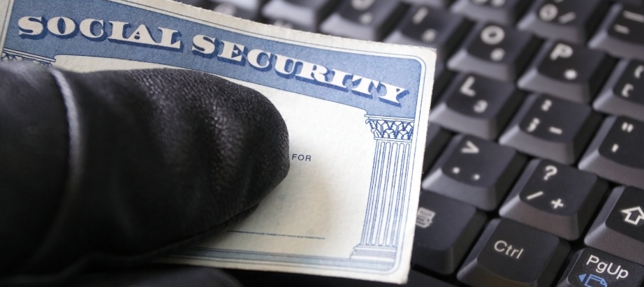a black glove holding a social security card