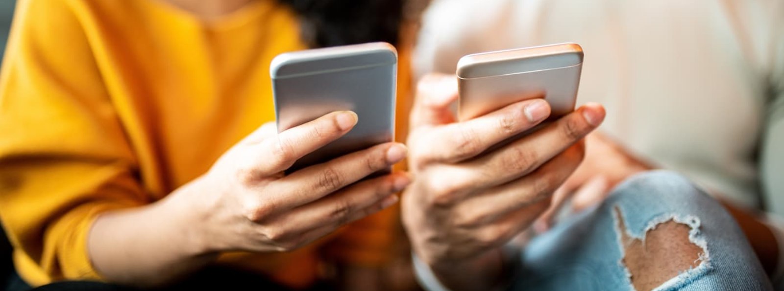 two people looking at their mobile phones